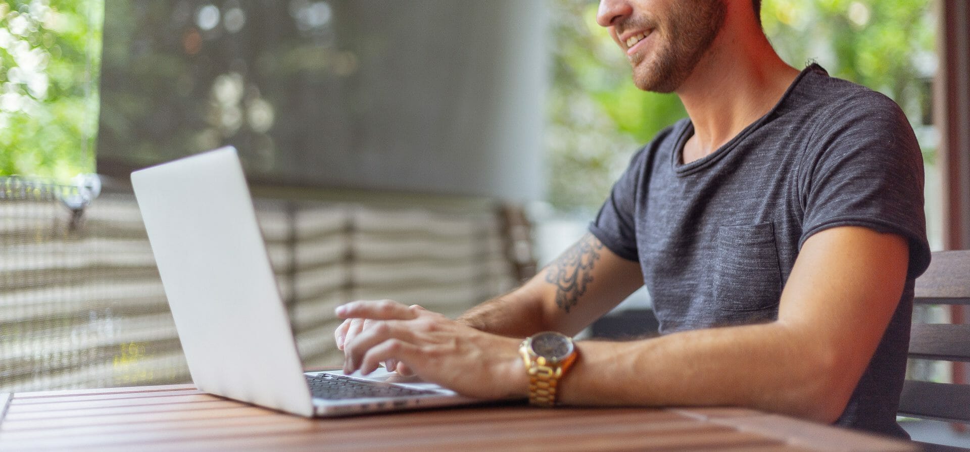 Seitenaufnahme eines Mannes, der an einem Schreibtisch sitzt und im Rahmen des Mitarbeiter-generierten Lernens auf einem Laptop tippt.