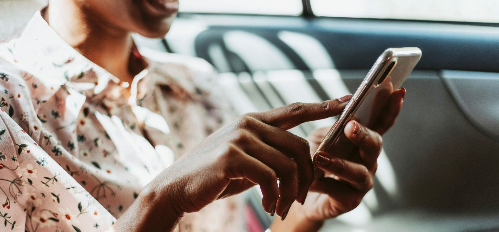 Una mujer utiliza el teléfono móvil dentro de un coche.