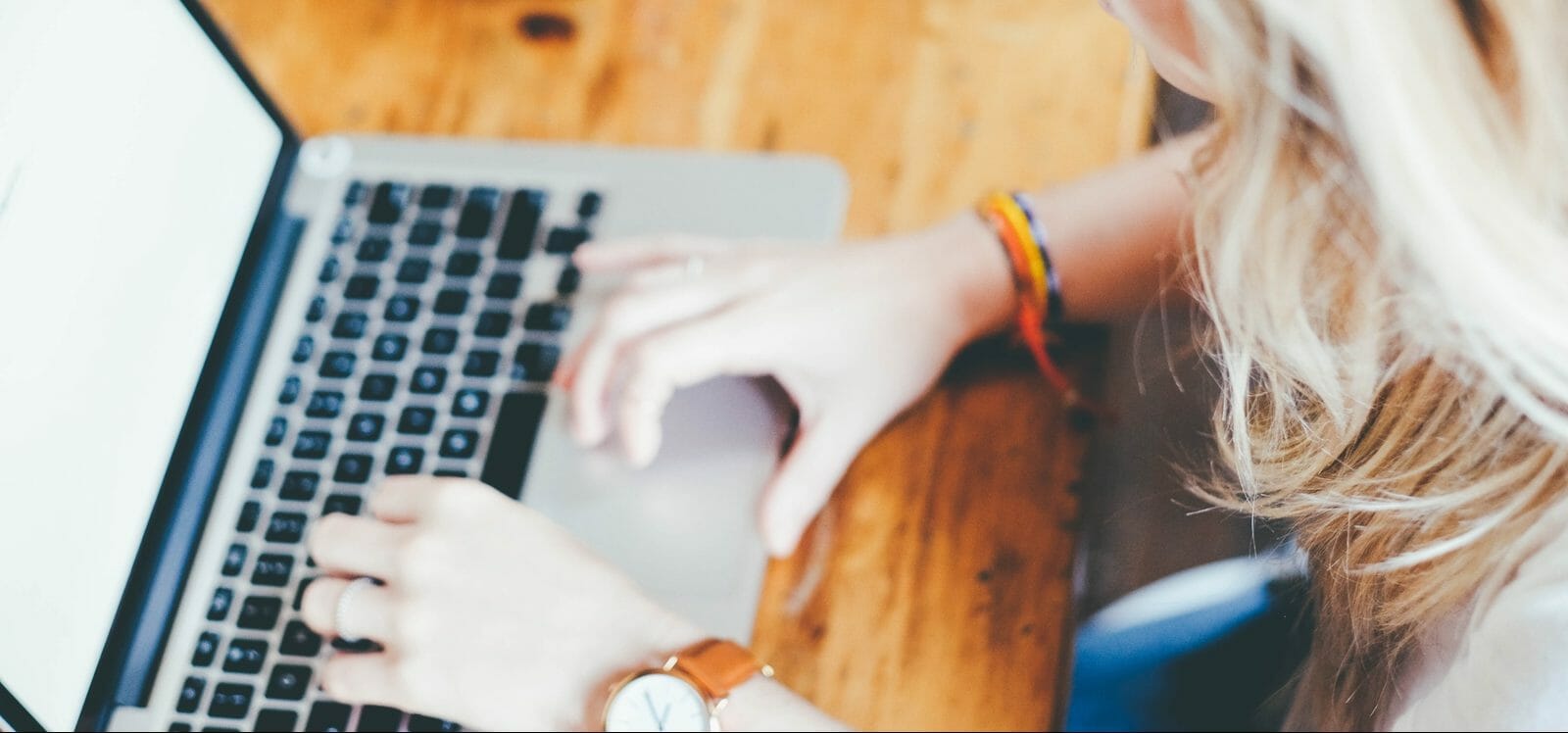 Personne tapant sur le clavier d'un ordinateur portable en utilisant un LMS.