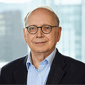 Professional man in glasses smiling in a business setting.